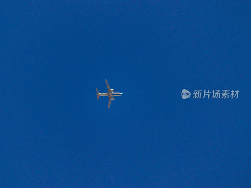 jet plane, flying at high altitude, crossing a cloudless blue sky.